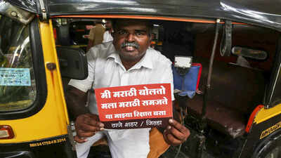 Thane: A man shows a sticker after the Maharashtra government plans to make Marathi language compulsory for autorickshaw and taxi drivers, in Thane. (PTI Photo) Maha mininster stalls action against auto, cab drivers on Marathi issue