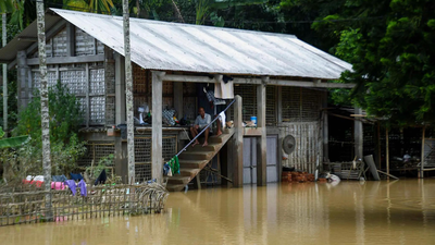 A resident sits on the steps of a flood-affected house surrounded by inundated water Assam flood toll rises: 21 killed in a day; over 5.6 lakh affected across 16 districts