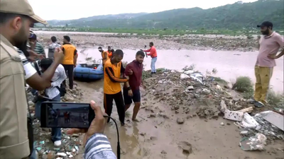 An NDRF personnel evacuates a youth from the middle of the Tawi river Police, SDRF rescue 2 trapped in Tawi river; Army launches relief ops in Reasi, Rajouri