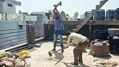 MCD workers break concrete slabs on the rooftop of a PG during a demolition drive against illegal construction in Laxmi Nagar, in New Delhi (ANI photo) MCD demolished 34 structures, sealed 17; over 1,200 PG buildings surveyed